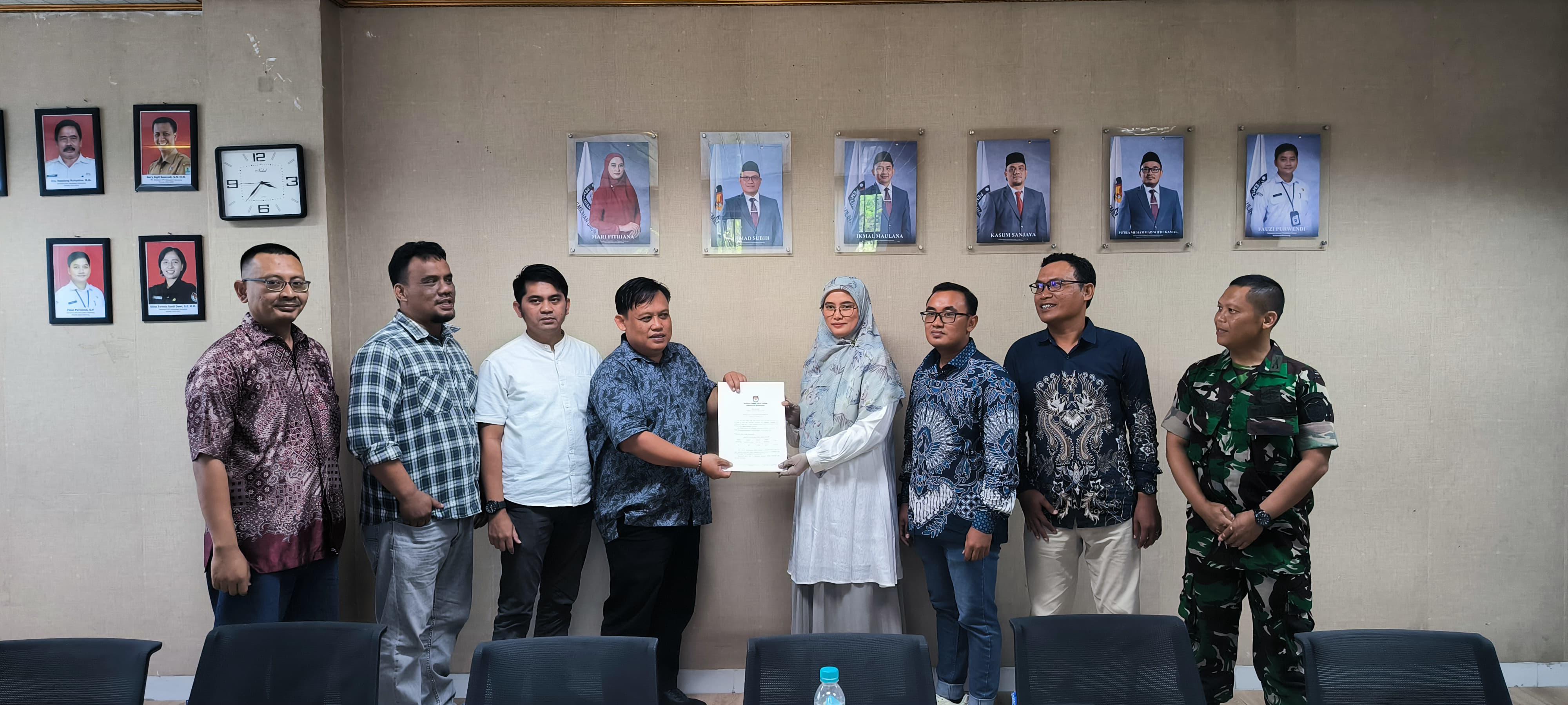 Kordiv. PPHM Bawaslu Kabupaten Karawang Ade Permana menerima salinan Berita Acara Pleno PPDB Triwulan III dari Ketua KPU Kabupaten Karawang Mari Fitriana, Jum'at (03/10/25).