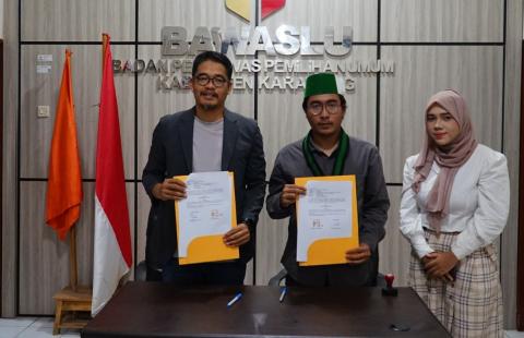 Ketua Bawaslu Kabupaten Karawang Engkus Kusnadi bersam Ketua Cabang HMI Karawang Satria Barqi didampingi pengurus, saat penandatangan kerja sama di Kantor Bawaslu Kabupaten Karawang, Rabu (16/09/2026).
